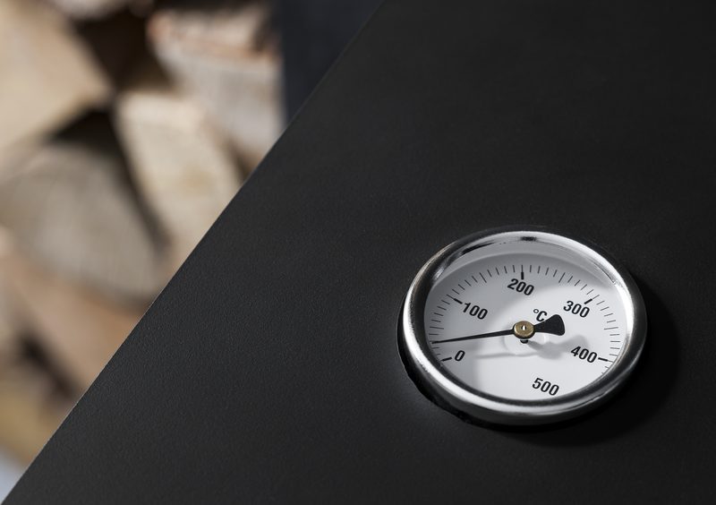 Close-up of a stove flue temperature gauge showing operating temperature